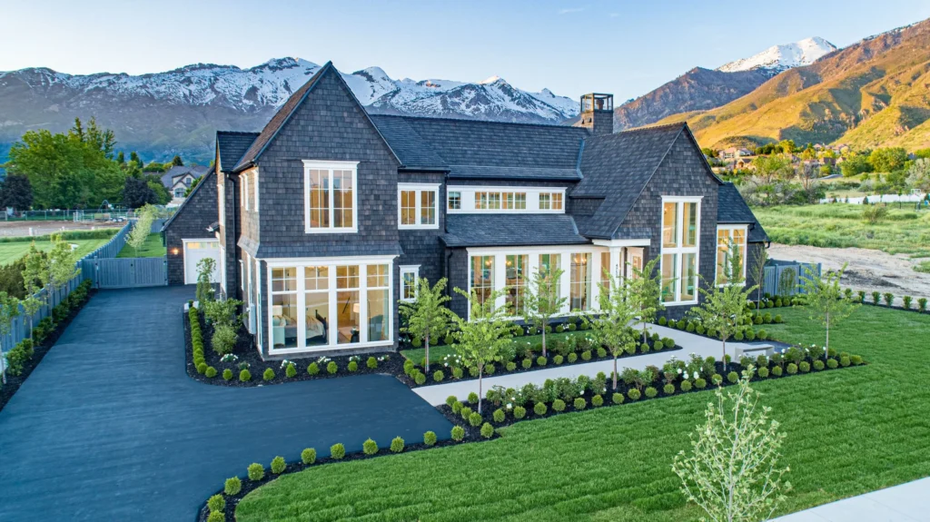 Large custom home with a CeDUR synthetic shingle roof set against a mountain landscape.