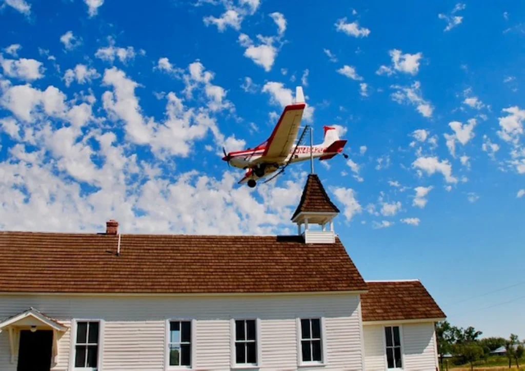 Airplane flying over a custom home with CEDUR shingles.