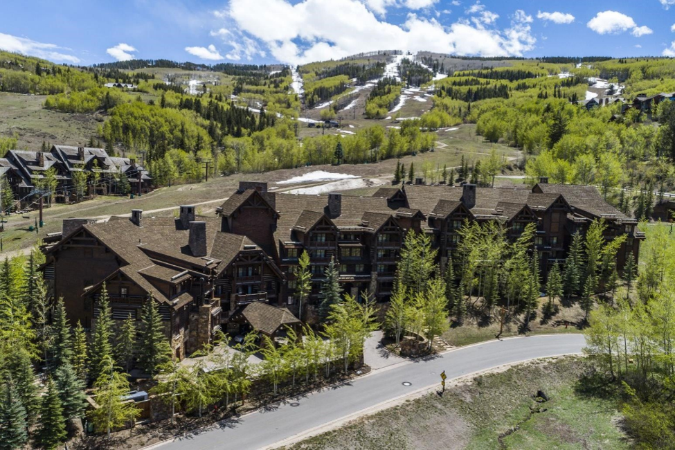 Luxury mountain resort with a CeDUR synthetic shingle roof overlooking a scenic ski slope.