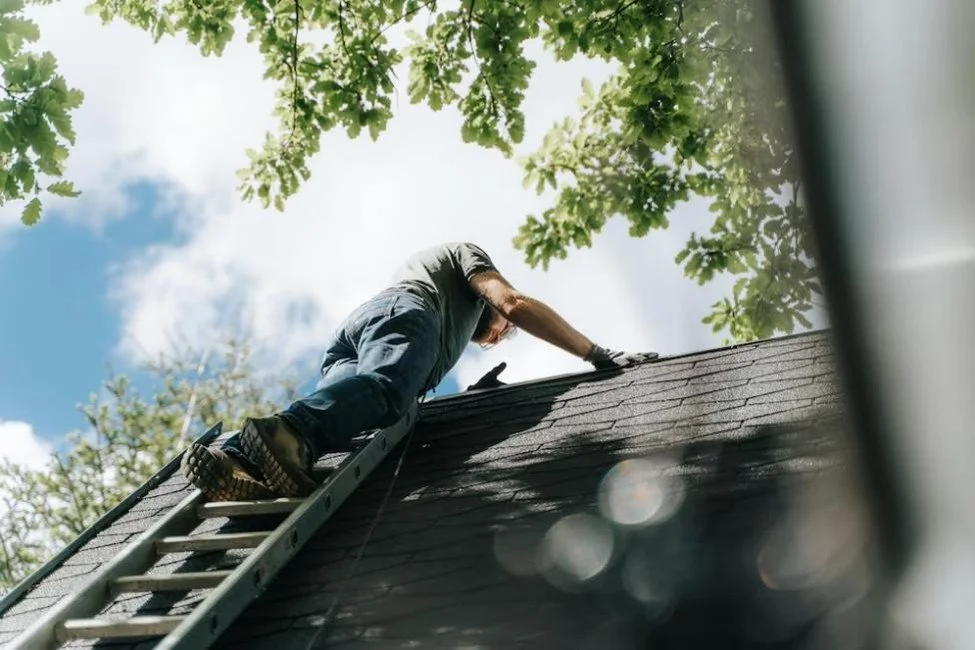Roof inspector examining the condition of an older residential rooftop during a homeowners insurance evaluation.