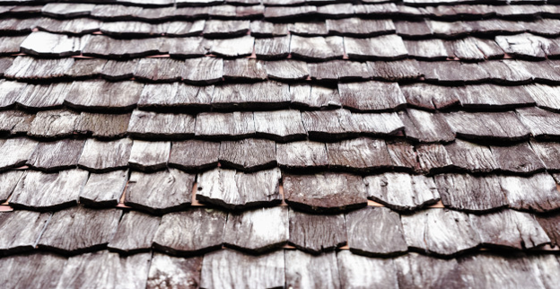 Damaged hand split cedar composite roofing shakes.