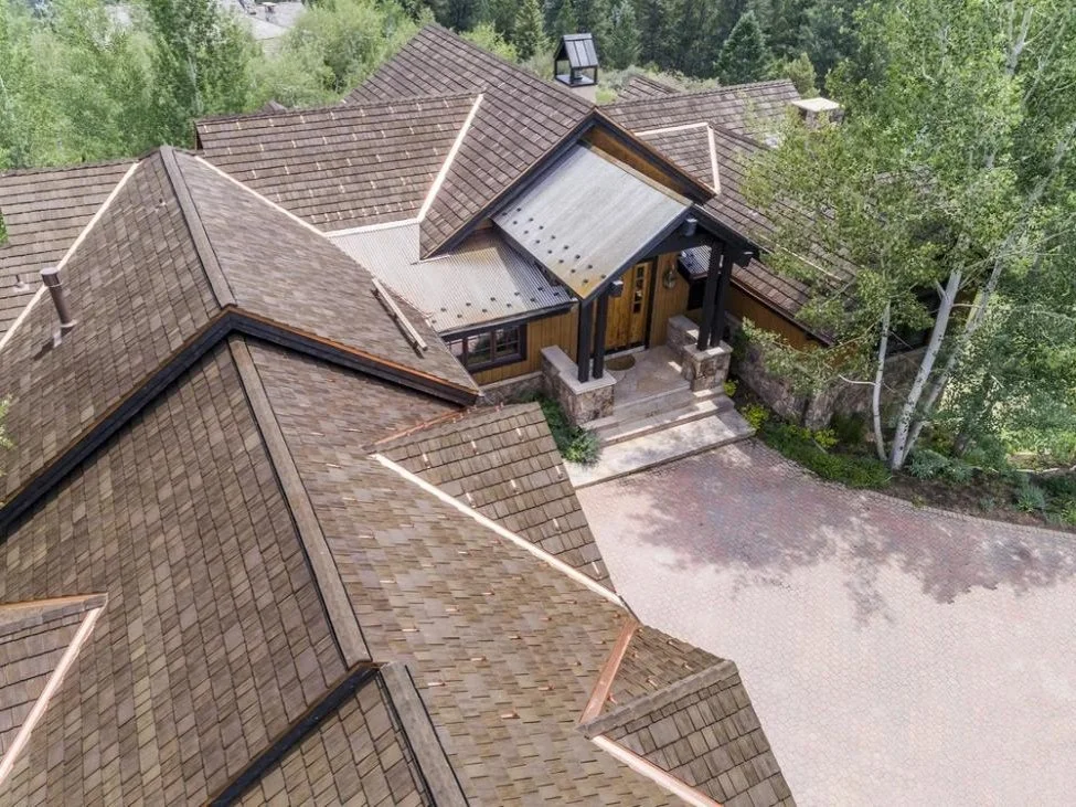 Brown roof blending into forested Colorado mountain landscape