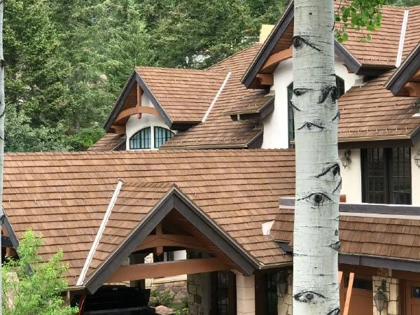 Close-up of a home featuring CEDUR composite roofing in Live Oak color with multiple rooflines.