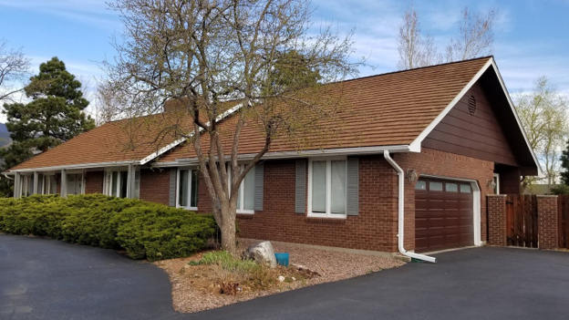 House with CEDUR Golden Cedar roof and brick exterior.